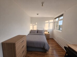 A bedroom with a bed, bedside table, lamp, and a window. - Spacious house in Greater London
5 bedrooms 5 bathrooms (London)