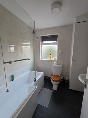 A modern bathroom with a bathtub, toilet, and a window. - Spacious house in Greater London
5 bedrooms 5 bathrooms (London)