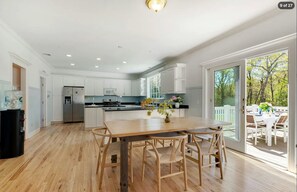 Dining and kitchen space featuring hardwood floors and sliding doors to the deck. - Hamptons Retreat | Private Pool & 3BR Escape (East Quogue)