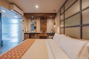 Una habitación de hotel con cama, baño y kitchenette.