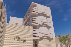 Edifício moderno com fachada geométrica e entrada visível.