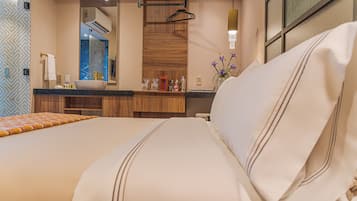 Una habitación de hotel con una cama, un baño con espejo y una ventana.