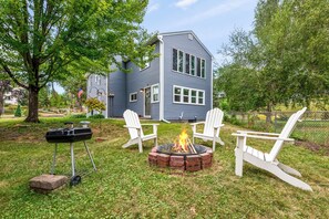 A house with a fire pit and two Adirondack chairs in the yard. - Lakefront 5BR Retreat on Lake Phalen-Sleeps 14-Fire Pit & Workspace (Saint Paul)