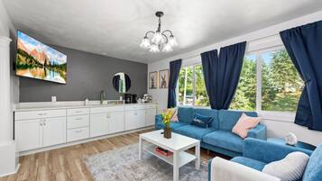A modern living room with a sofa, coffee table, and a painting on the wall.