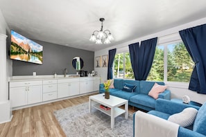 A modern living room with a sofa, coffee table, and a painting on the wall.
