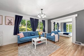 Un salon moderne avec deux canapés, une table basse et un lustre.