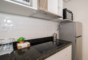 Induction cooktop and range hood - Sunny Retreat with Pool, Gym and City Views (Asunción)
