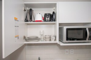 Kitchen cabinet with dishware - Sunny Retreat with Pool, Gym and City Views (Asunción)