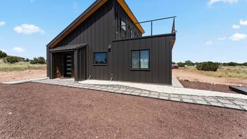 A modern two-story house with a sloped roof, a garage, and a paved driveway.