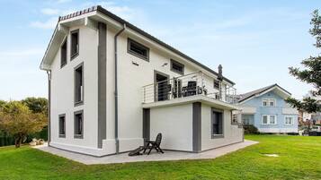 A two-story residential building with a balcony and a small outdoor seating area.