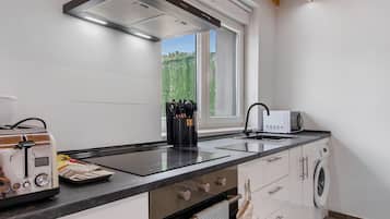 Una cocina moderna con horno integrado, microondas y lavamanos.