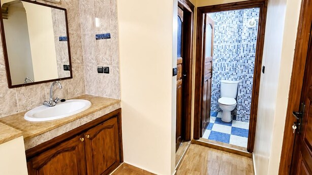 Ein Badezimmer mit Waschbecken, Spiegel und Holzschränken.