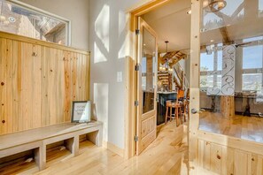Entryway with built-in storage bench and French doors leading into the main living area. - Cutbow Lodge | Mountain Views + Hot Tub + Wolf Crk (South Fork)