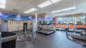 Et fitnesscenter med løbebånd, crosstrainere og træningsudstyr.
