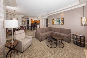 A modern living room with a sectional sofa, a small round table, and a lamp. - Stagecoach 2027 Rental at Marriott's Desert Villas I 2 Bedroom with full kitchen (Palm Desert)