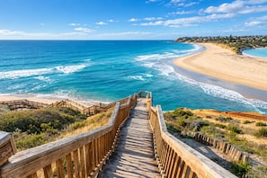 A wooden boardwalk leading to a beach with clear blue waters and a sandy shore. - Onkaparinga Hideaway Beach Days and Reef Adventures (Port Noarlunga)