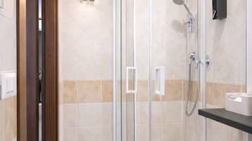 Eine begehbare Dusche mit Glastür, einer Handbrause und einer Bedienfeld an der Wand.