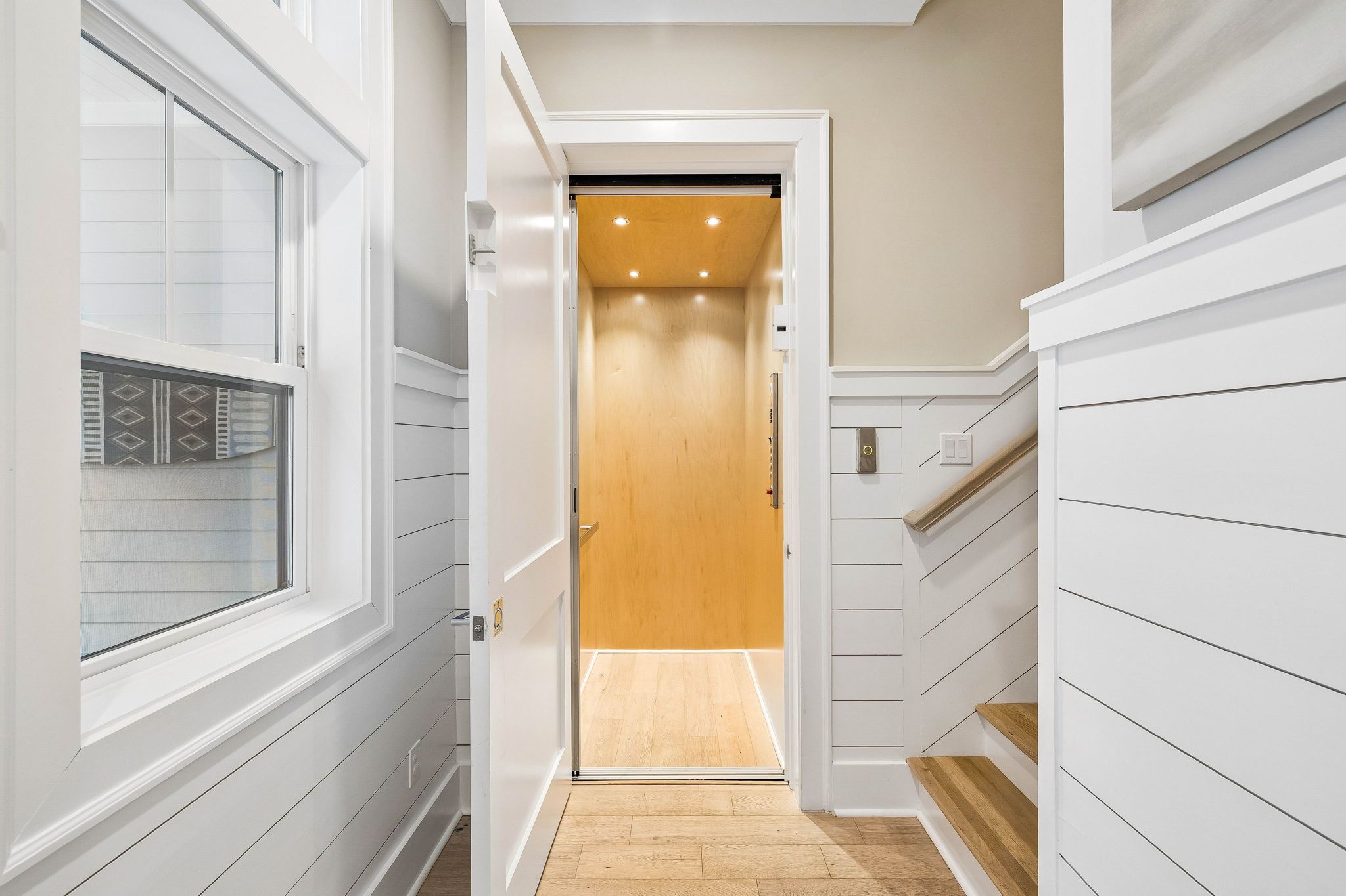 Your private elevator makes every floor of your home effortlessly accessible, blending modern convenience with stylish light wood finishes and recessed lighting for a warm, welcoming touch.