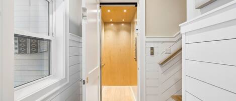 Your private elevator makes every floor of your home effortlessly accessible, blending modern convenience with stylish light wood finishes and recessed lighting for a warm, welcoming touch.