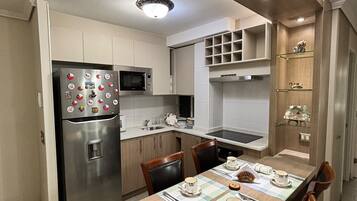 A modern kitchen with a built-in refrigerator, microwave, and a dining area with a table set for two.