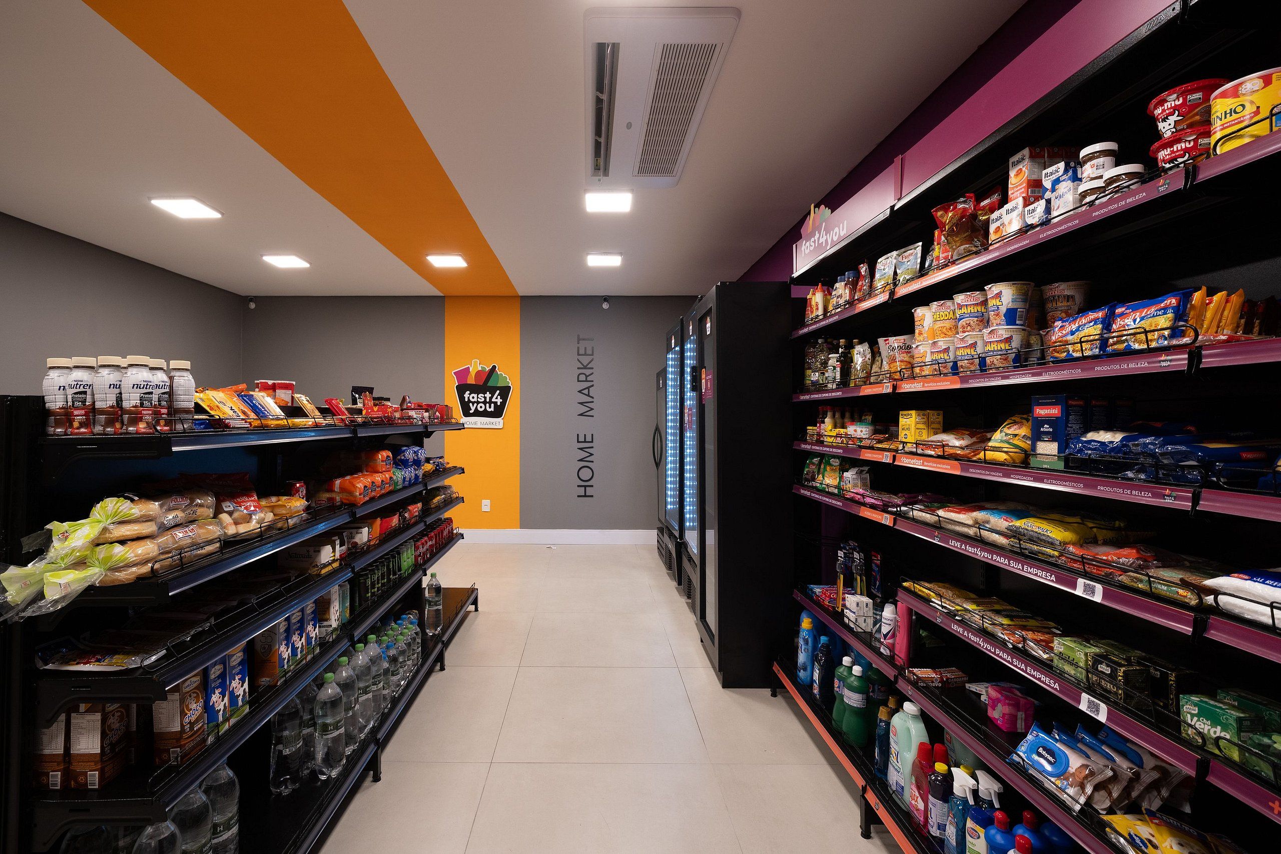 A grocery store aisle with shelves stocked with various products including bread, pasta, and beverages.