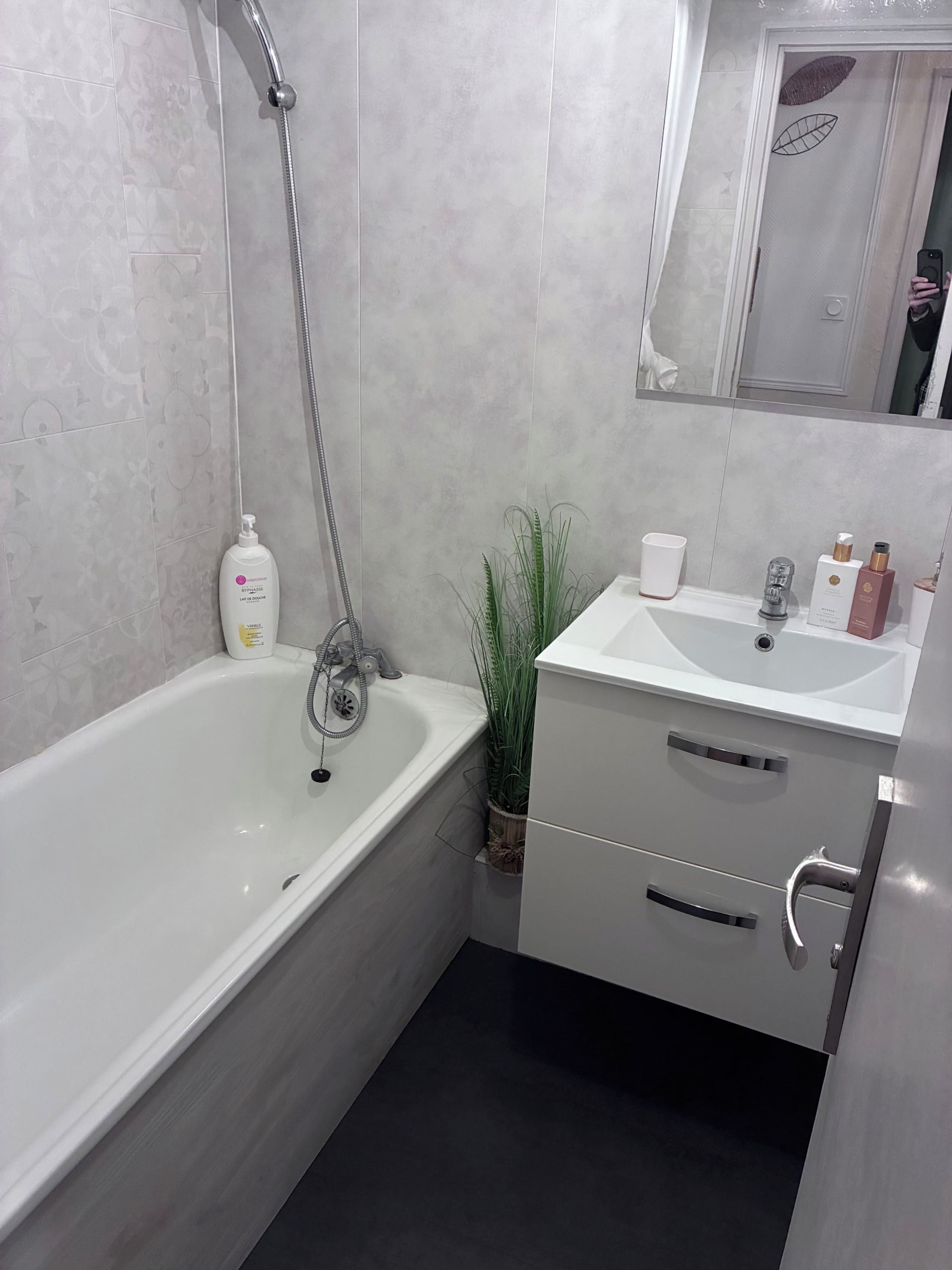 A modern bathroom with a bathtub, a sink, and a mirror.