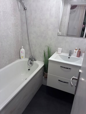 A modern bathroom with a bathtub, a sink, and a mirror.