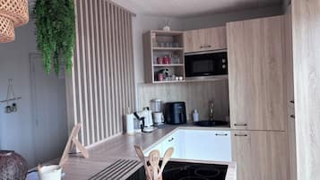 Eine moderne Küche mit einer eingebauten Mikrowelle, einer Kaffeemaschine und einem Spülbecken.