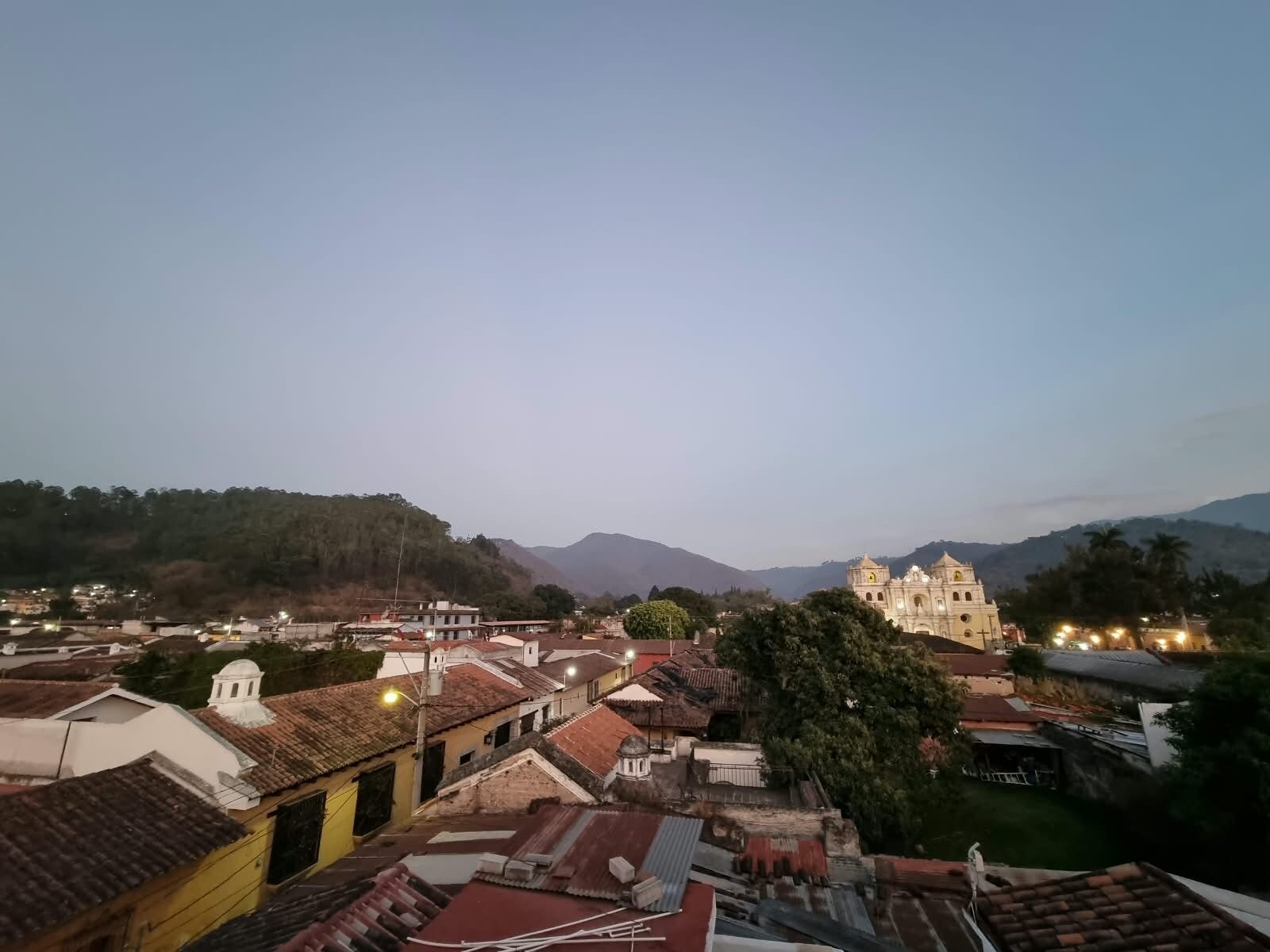 Un pueblo con edificios históricos y una iglesia destacada, rodeado de colinas.