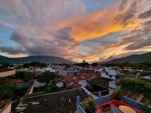 Un barrio residencial con casas, una montaña al fondo y un cielo al atardecer.