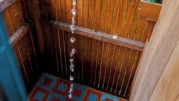 A wooden structure with a tiled floor and a water spout.