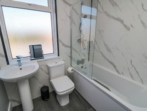 Une salle de bain avec un lavabo, des toilettes et une douche.