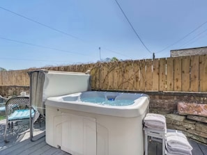 A hot tub on a wooden deck with a wooden fence in the background. - The Quirky Cottage (Penrith)
