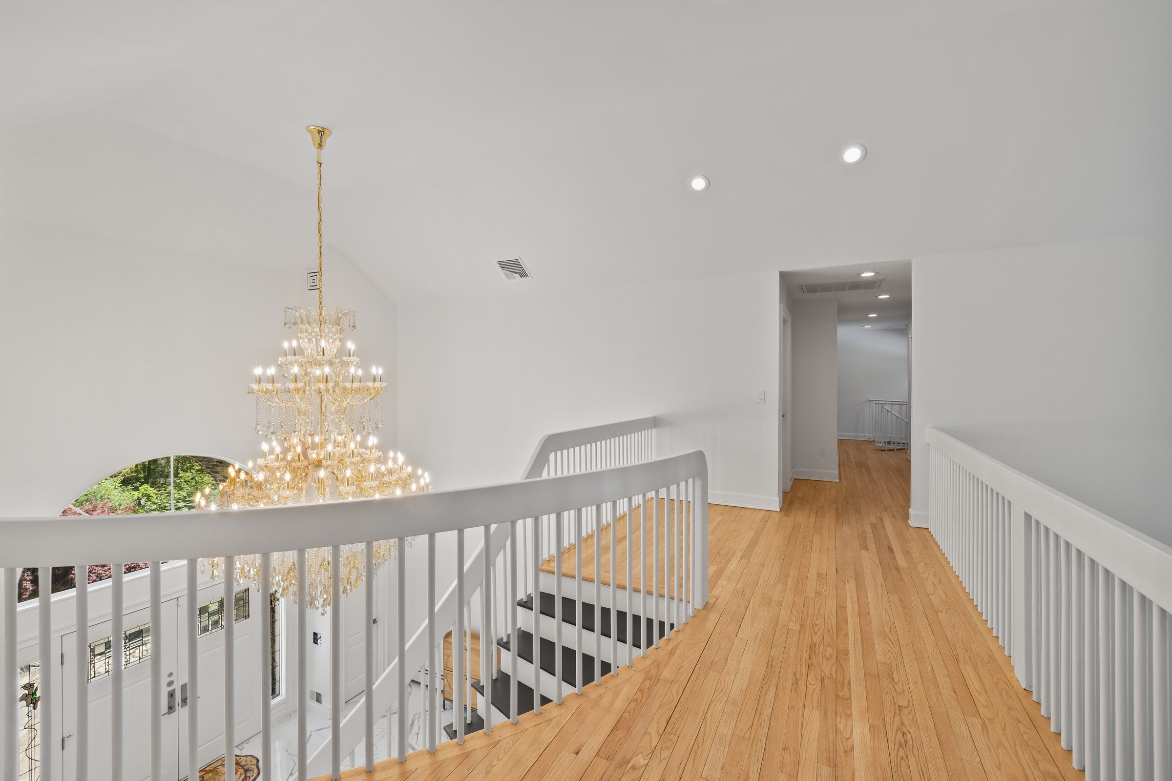 Una escalera con barandillas blancas y piso de madera que conduce a una plataforma.