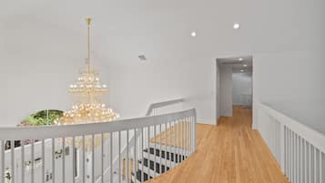 Una escalera con barandillas blancas y piso de madera que conduce a una plataforma.