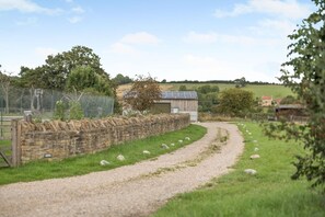 A rural landscape with a gravel path, stone wall, and a fenced area. - 2 Bed in York (oc-y008) (Gilling East)
