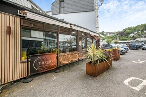 Ein Café mit Außenbereich und einem Schild mit der Aufschrift 'The Quay Cafe & Lounge Bar'.