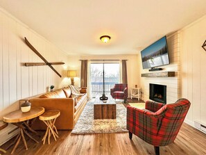 A living room with a sofa, armchair, coffee table, and a fireplace. - Renovated 2BR Mountain View Condo ½ Mile to Beech Mtn Resort (Beech Mountain)