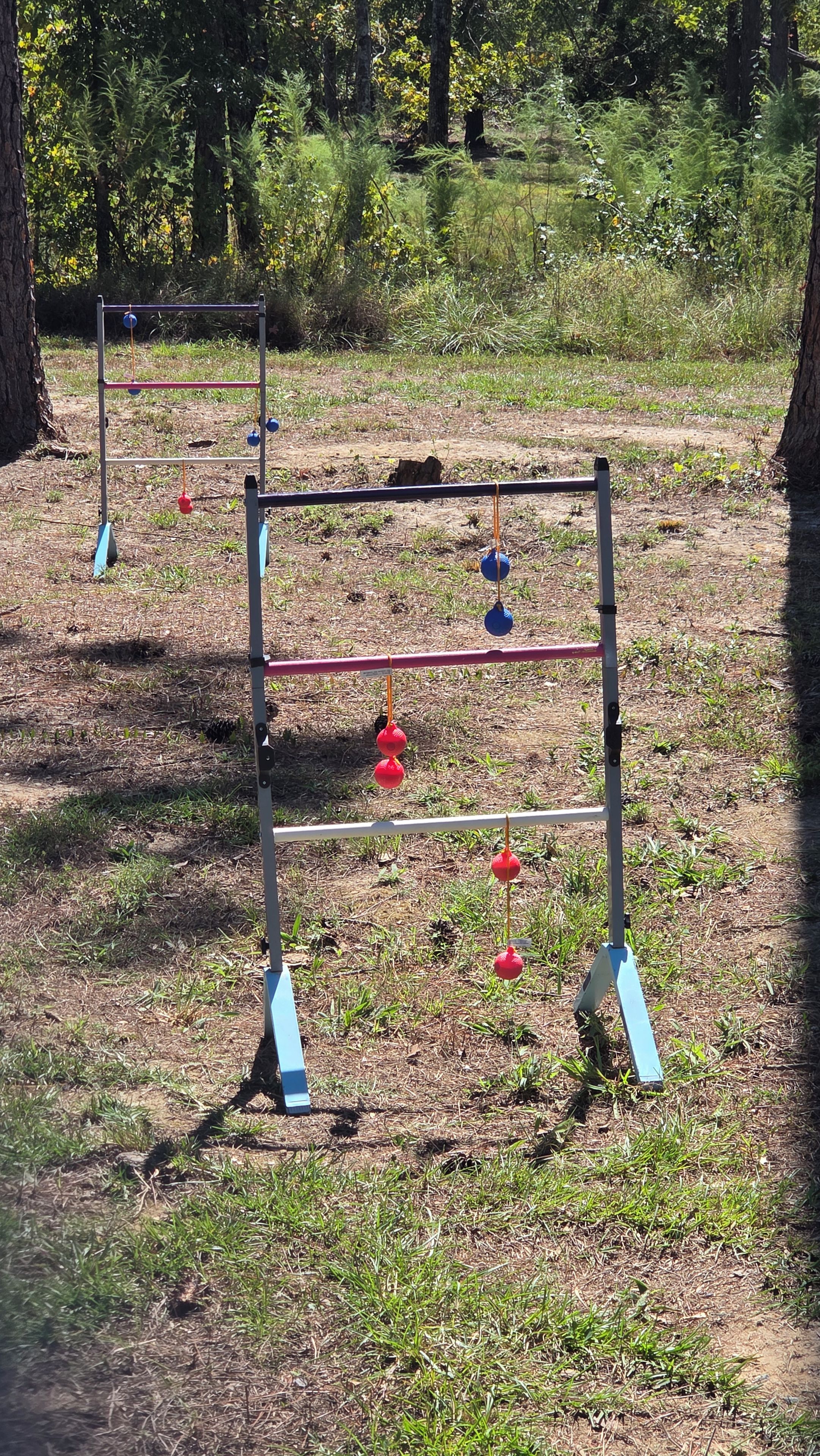 Un espace extérieur aménagé pour faire de l’exercice, avec une structure de barre de traction et des ballons d’exercice.
