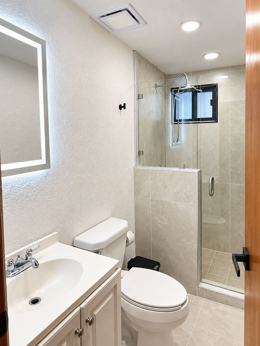 Un baño moderno con inodoro, lavabo y ducha.