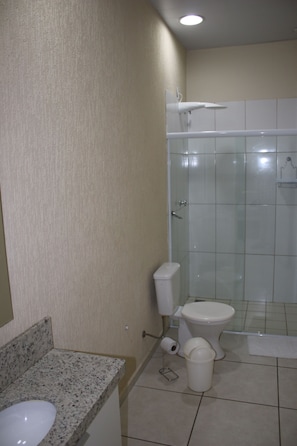 A bathroom with a toilet, shower, and sink. - Blu Apart Hotel (Mogi-Guacu)