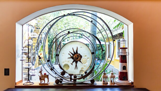 A decorative clock with concentric circles and a lighthouse model. - Vrbo Property (Unknown)