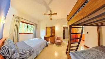 Une chambre avec des lits superposés, un bureau, une chaise et un ventilateur de plafond.