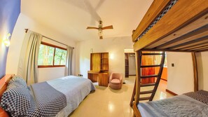 Una habitación con literas, un escritorio, una silla y un ventilador de techo.