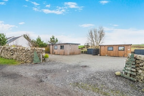A gravel driveway leading to a wooden building with a stone wall on one side. - 1 Bed in Gatehouse Of Fleet (oc-t34445) (Gatehouse of Fleet)