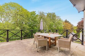 An outdoor patio with a table and chairs, surrounded by a black metal railing. - 5 Bed in Devizes (oc-s34742) (Devizes)
