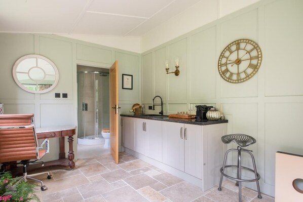 Une cuisine moderne avec un îlot central, un miroir rond et une horloge murale.