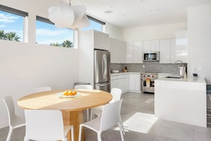 Share breakfast, snacks, and evening drinks in the sunny dining area beside the modern kitchen. - Modern Oasis in Central Palm Springs (Palm Springs)