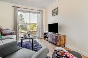 A modern living room with a sofa, coffee table, TV, and a view of the outdoors. - 2 Bed in Freuchie (oc-h34757) (Freuchie)