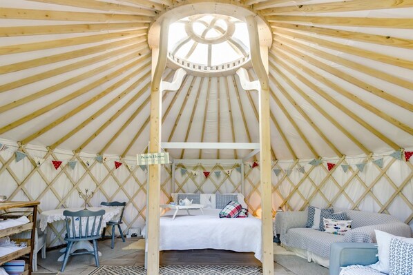 A yurt with a bed, a table, and a chair.
